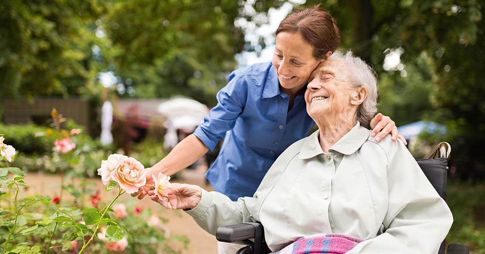 Seniorin und Pflegerin im Garten